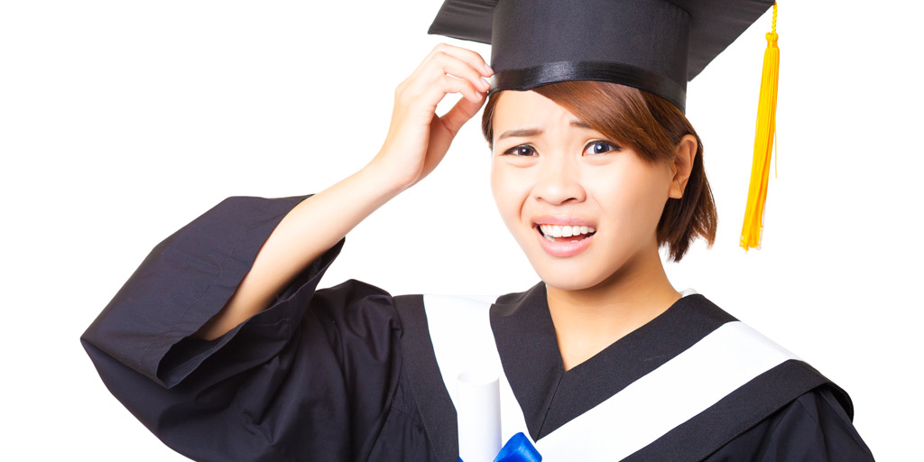 Woman in graduation cap with a confused look on her face.