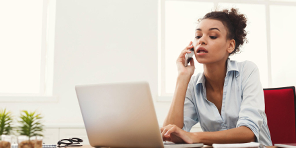 Woman on phone while working on laptop