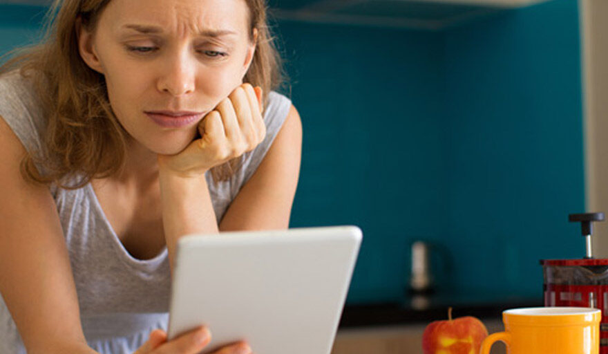 Woman staring at tablet looking disappointed