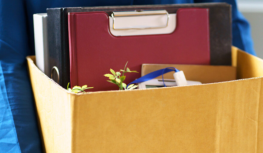 Man carrying cardboard box with desk items