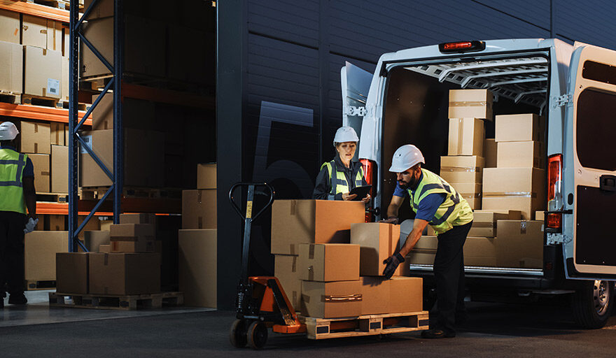 Warehouse Workers loading a van with packages.