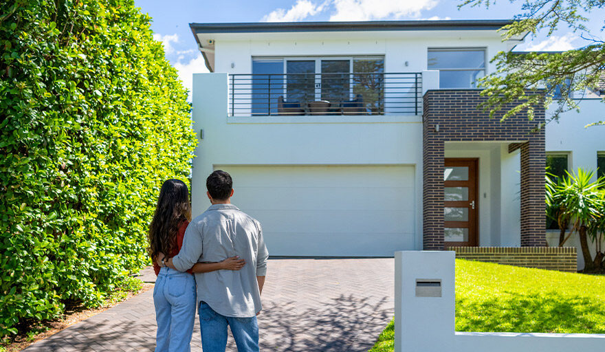 Couple standing in front of a house with their backs to the camera