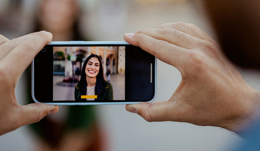 A cellphone capturing an image of a woman on the phone.