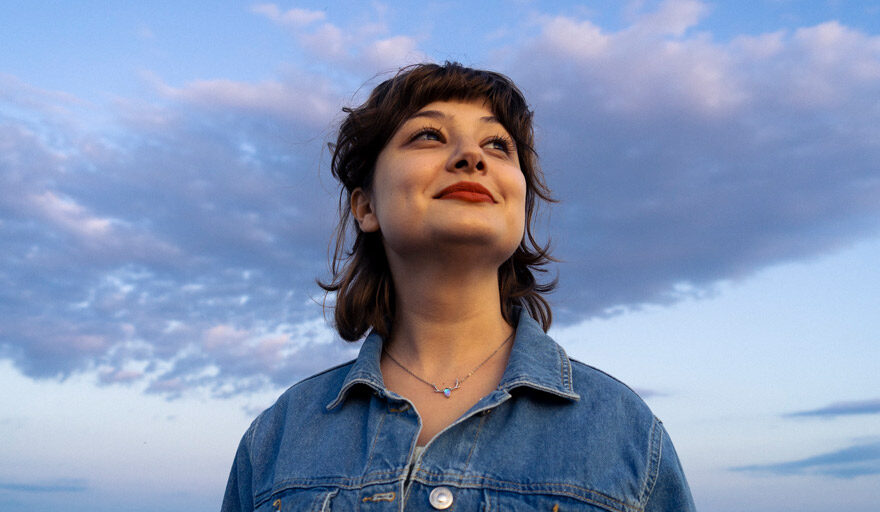 Woman looking confident in front of a blue sky.