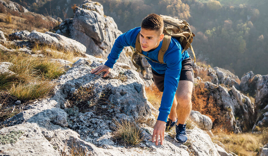 Young man climbing a mountain.
