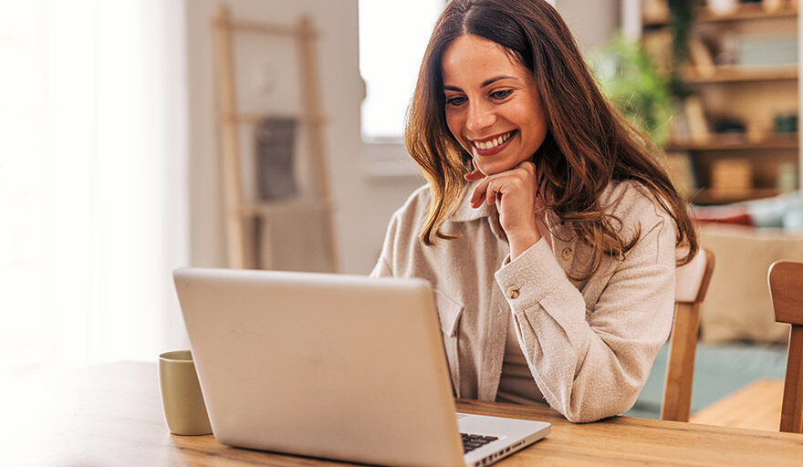 Woman on laptop and smiling.
