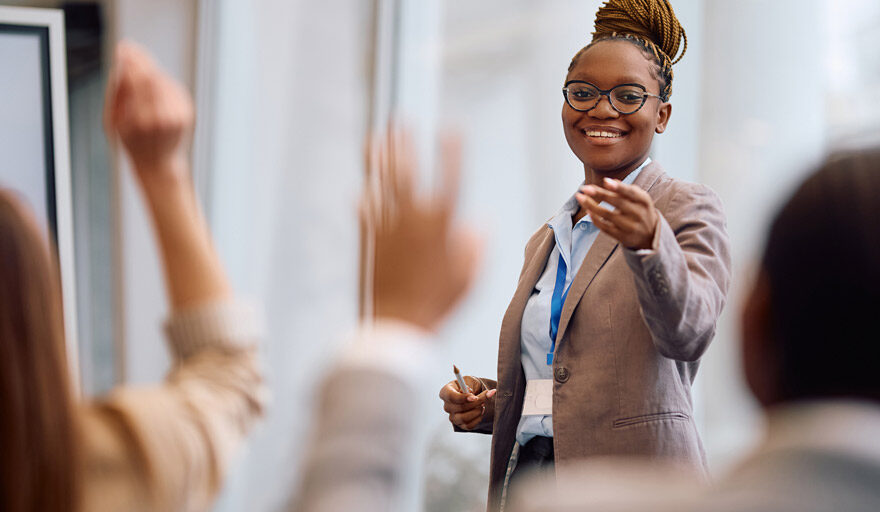 Professional woman standing in front of a group giving a presentation